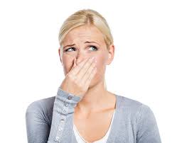 woman holding her nose because of bad smell in the bathroom